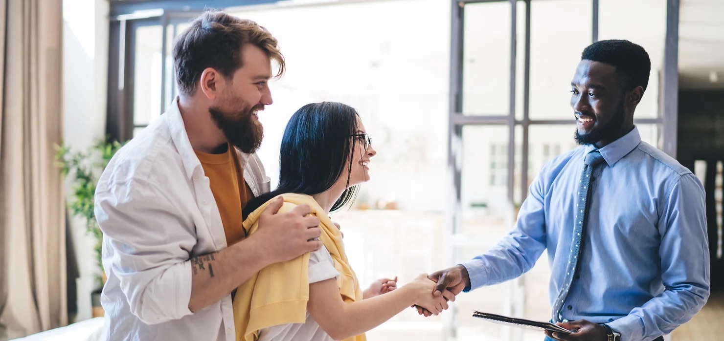 couple shaking hands with a realtor