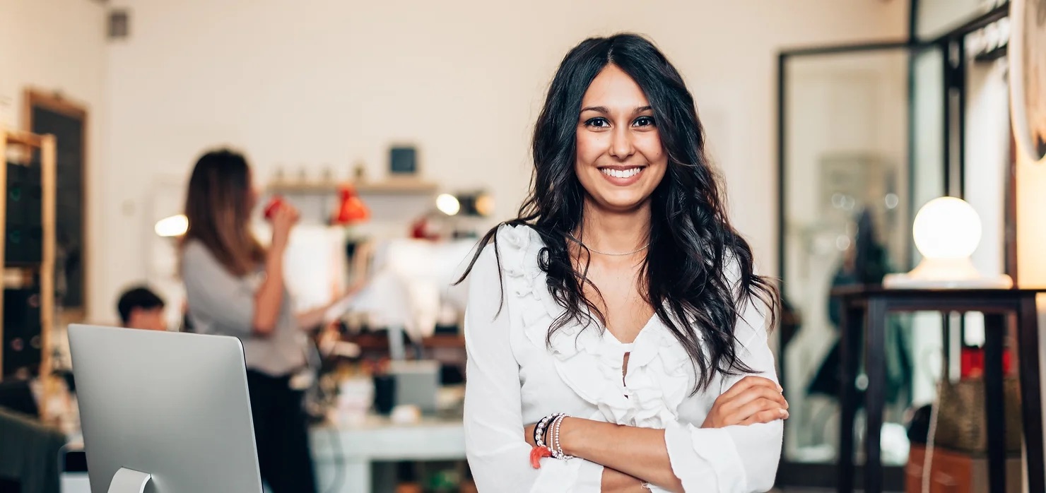 middle-aged woman smiling while crossing arms